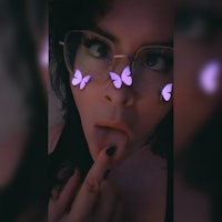 a woman wearing glasses with purple butterflies on them